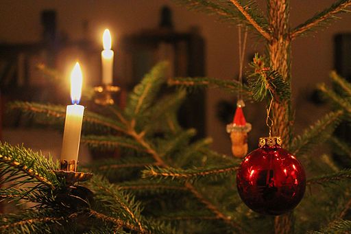 Christmas tree with red christmas bauble and christmas candles. Attribution: indeedous/Wikimedia Commons