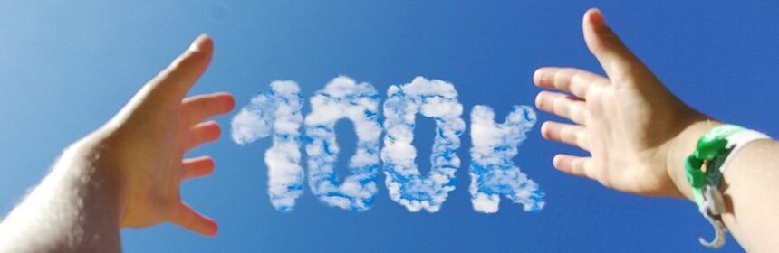 Picture of hands reaching out for clouds in the shape of 100K