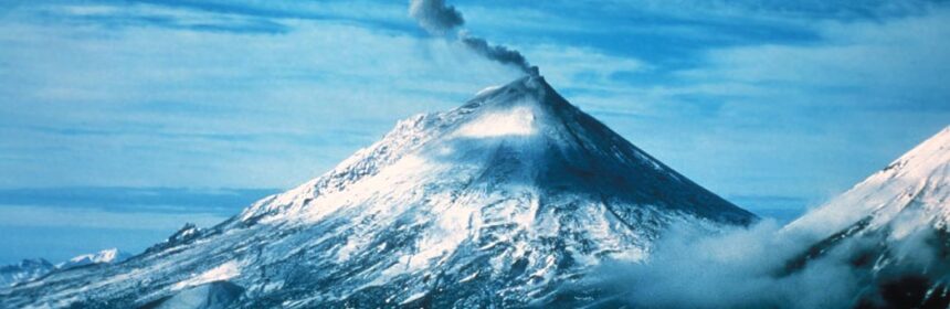 A photo of a volcano in Alaska as steam and volcanic gas rises
