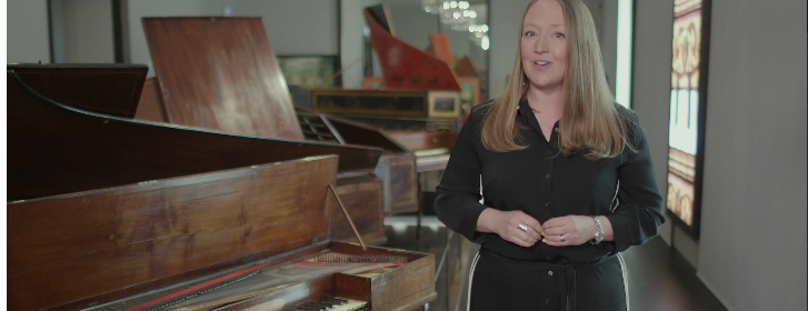 Dr Sarah Deters standing next to a piano