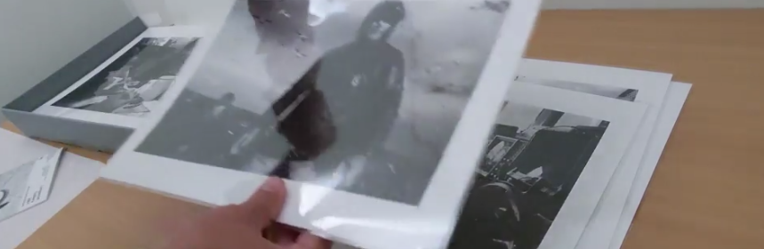 An archivist holding photographs from the Sutton-Hibbert collection
