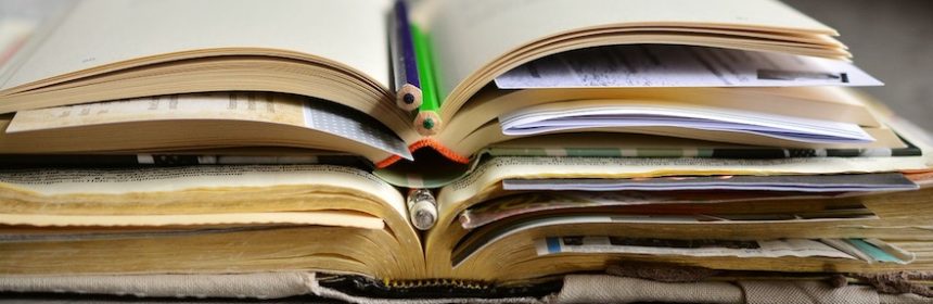 Pile of books with slips of paper inside the pages.