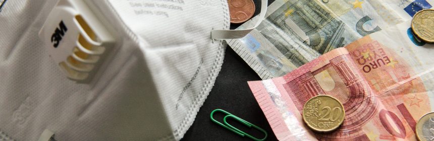 PPE facemask next to keyboard and Euro money