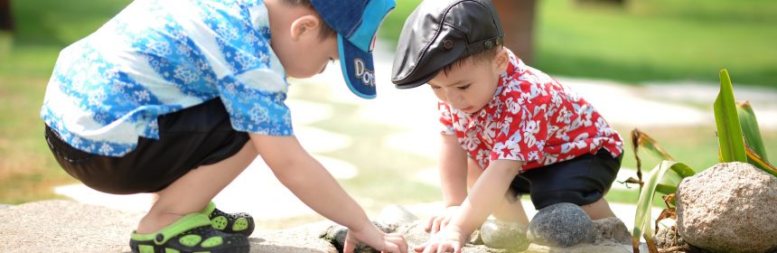 Two children playing in pond