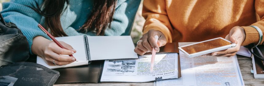 diverse women students studying together in park