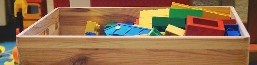 Wooden box with yellow, green, blue, and red duplo blocks.